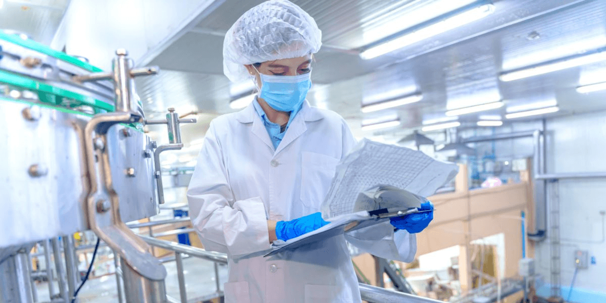 Two scientists in lab coats and masks collaborate on a research project in a laboratory setting.